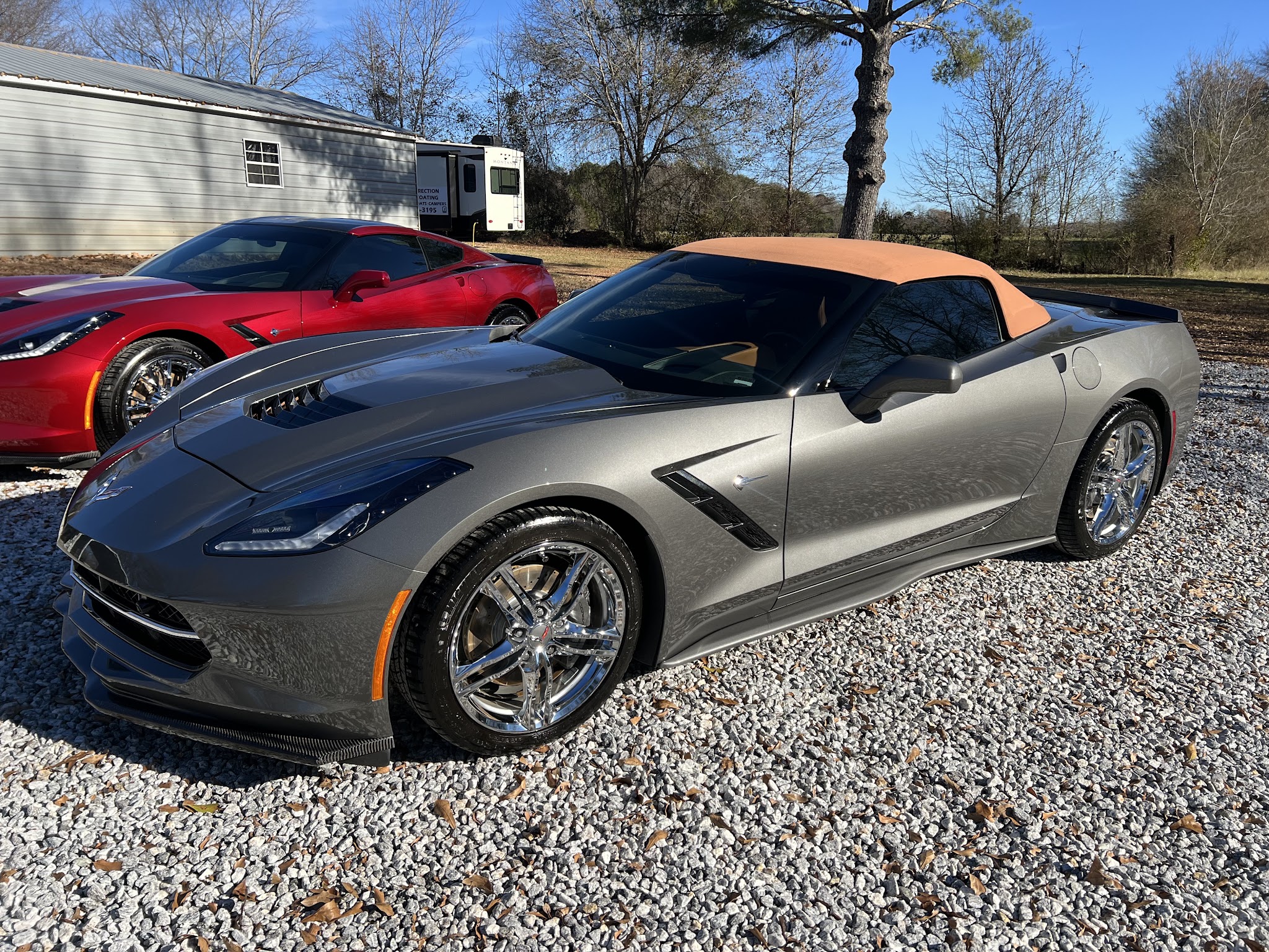 Grey Corvette Stingray with a tan roof, detailed outdoors